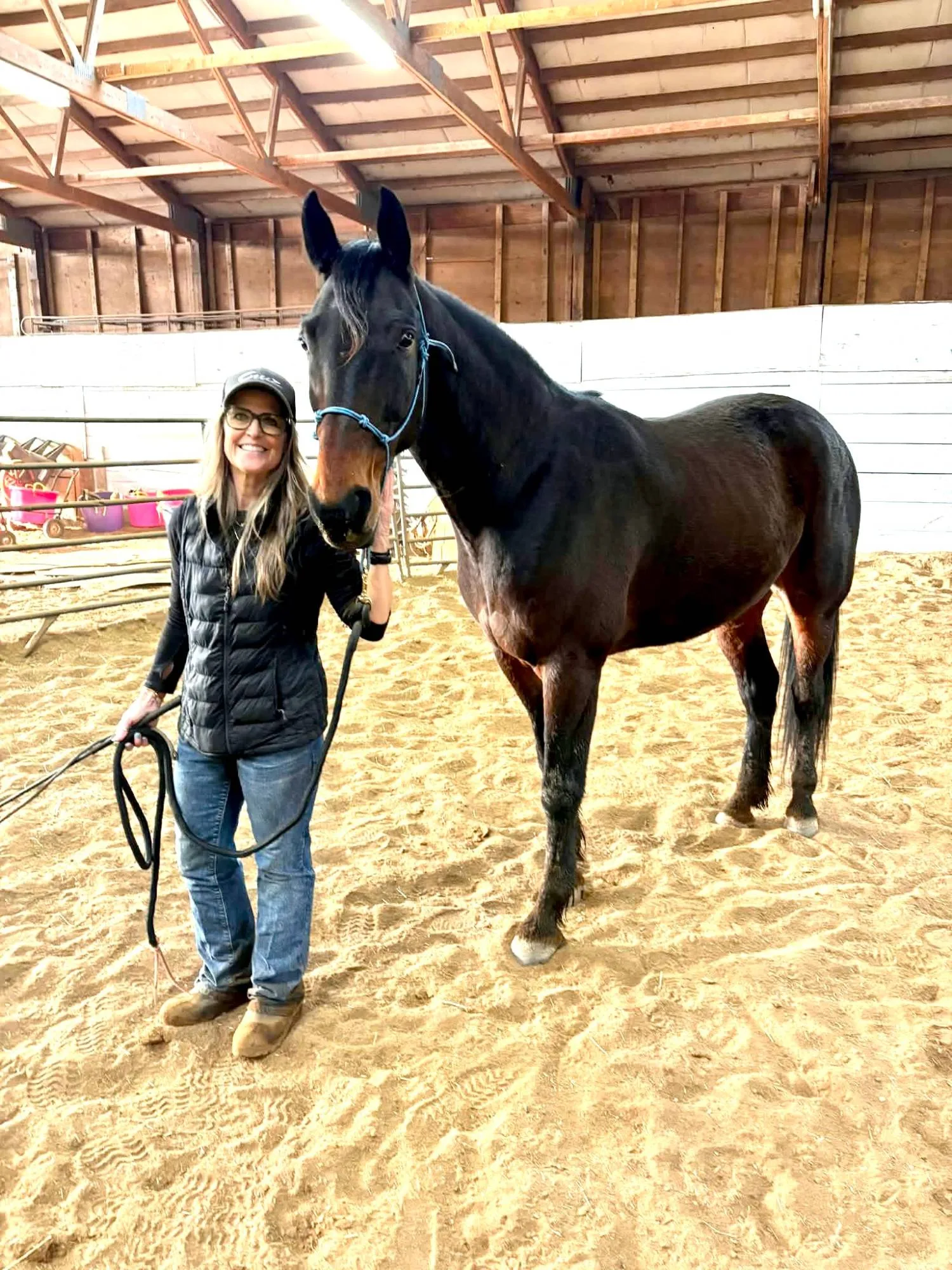 Lori standing with Artspire in the indoor arena, holding his lead rope